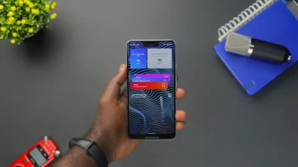 Mão segurando um telemóvel com notificação de atualização ou segurança na tela