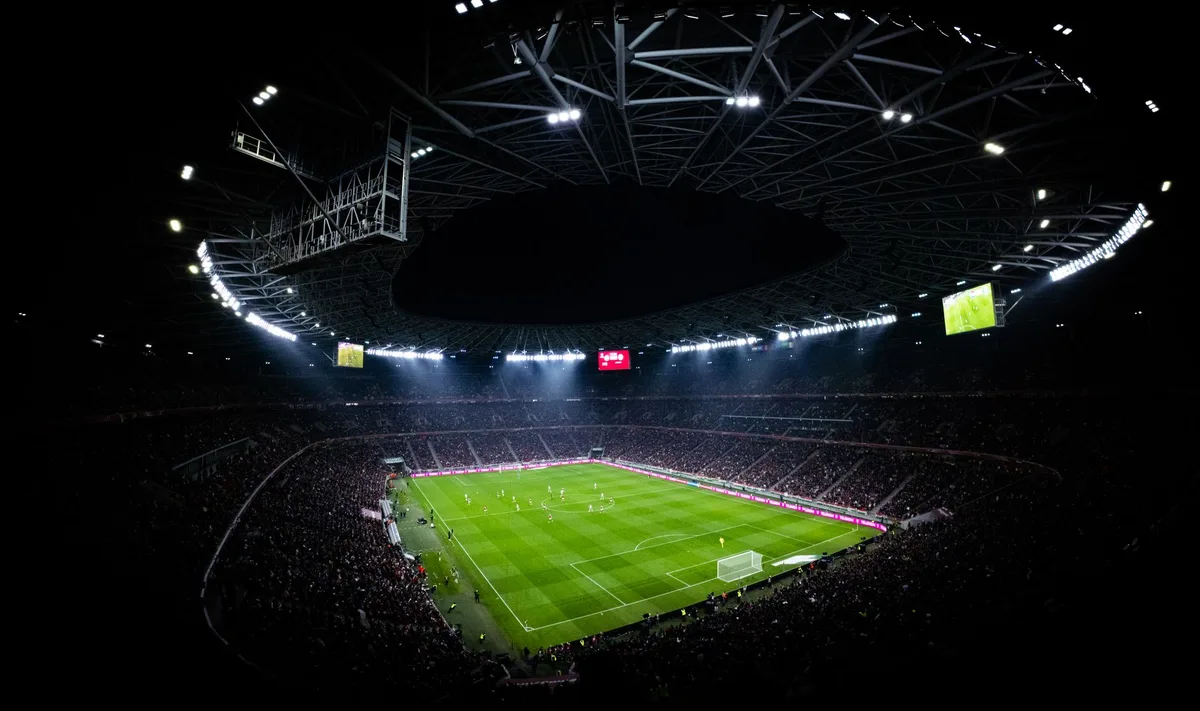 Est&aacute;dio de futebol iluminado para partida noturna