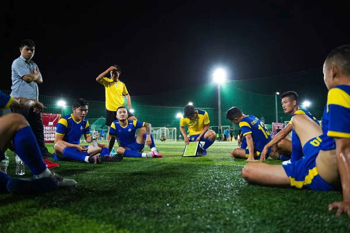 Treinador de futebol em conferência de imprensa, explicando estratégia tática