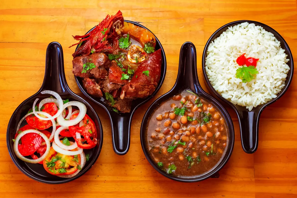 Prato de cozido à portuguesa com carnes variadas, enchidos, legumes e arroz servido em travessa
