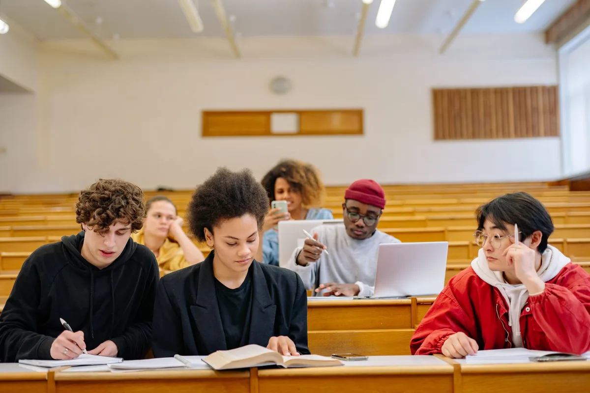 Alunos de diferentes origens em atividade colaborativa numa sala de aula iluminada