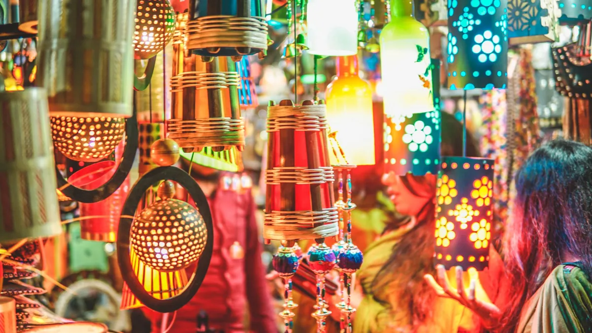 Bancas de artesanato e mercado iluminadas durante a festa noturna.