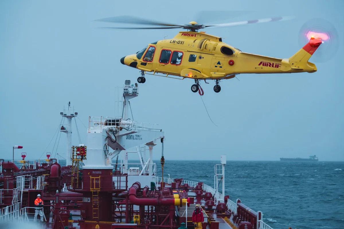 Helicóptero de resgate em operação noturna sobre águas do oceano