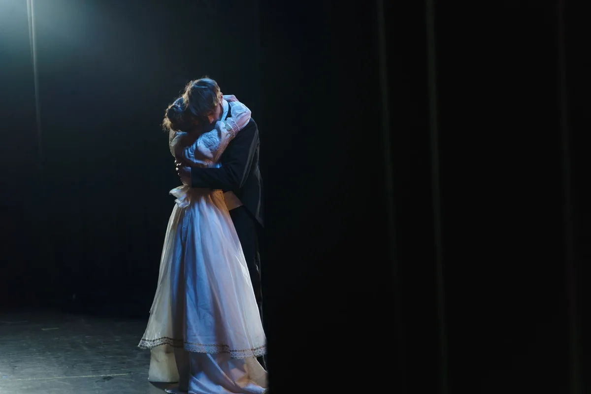 Dois atores em cena teatral, evocando parcerias artísticas e profissionais duradouras