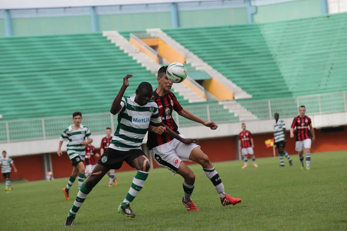 Jogador de futebol em ação durante um jogo, driblando a alta velocidade