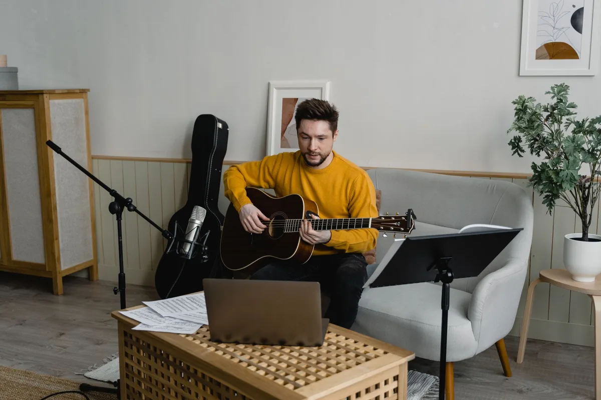 Artista em estúdio durante videochamada de coordenação com produtor.