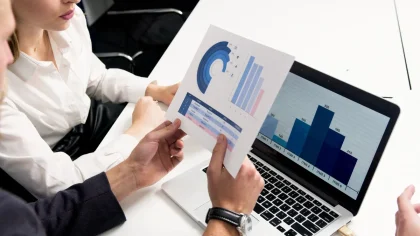 Documentos financeiros e gráficos de lucros crescentes numa secretária de escritório bancário