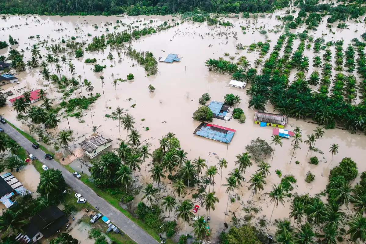 Paisagem rural inundada com estradas submersas, postes de comunicações e energia danificados, após tempestade extrema
