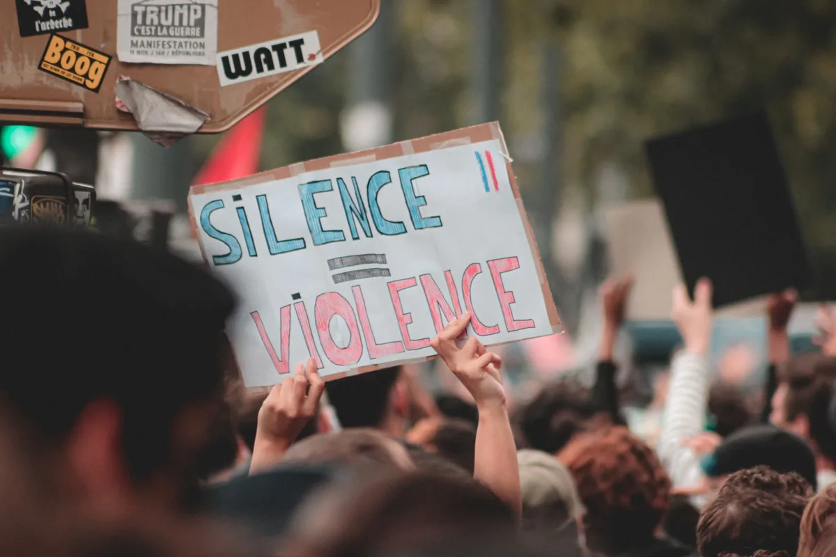 Cena de confronto político violento em rua histórica, com figuras em silhueta