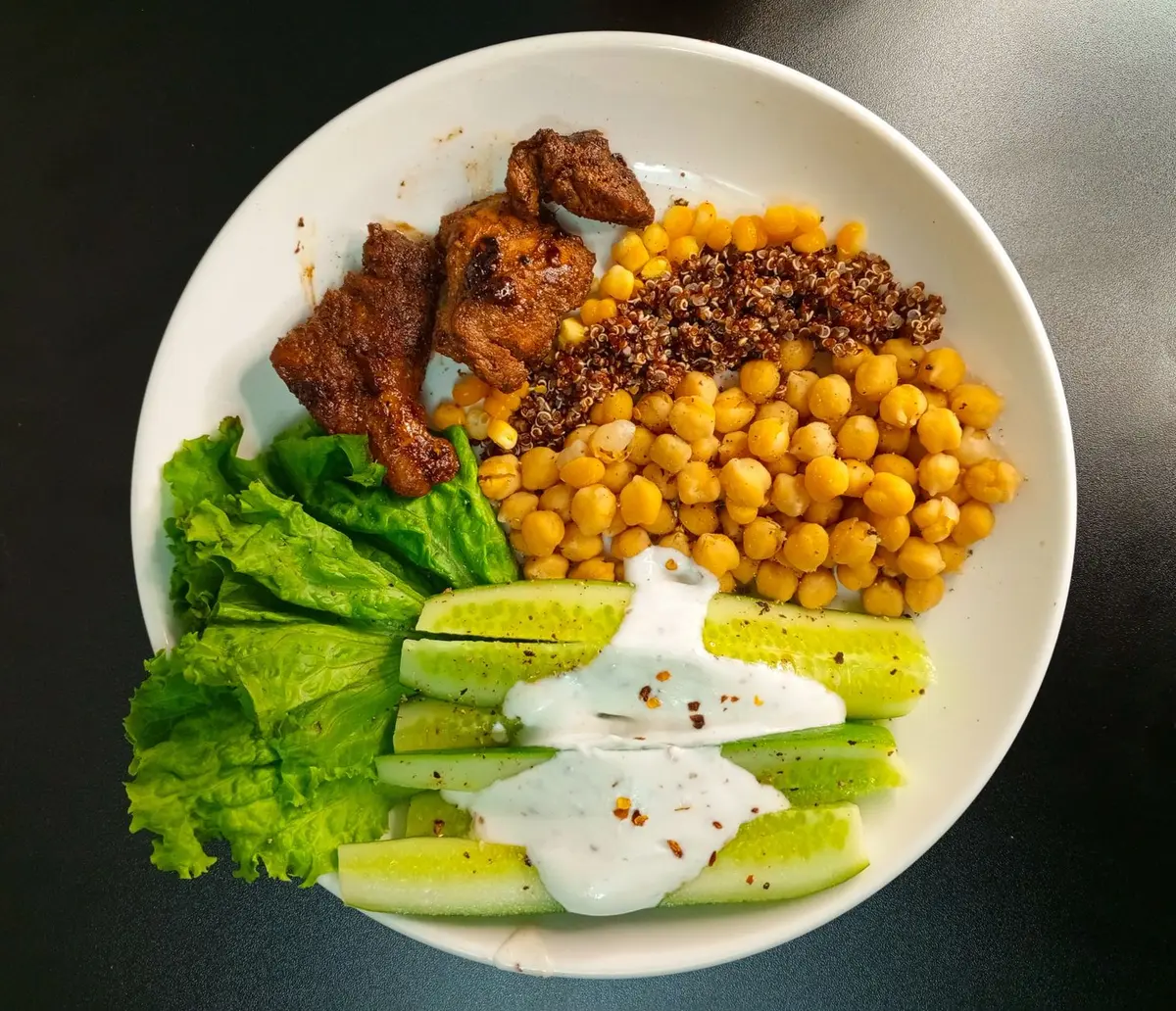 Ingredientes da salada: grão-de-bico, frango, tomate, alface e azeite dispostos numa bancada