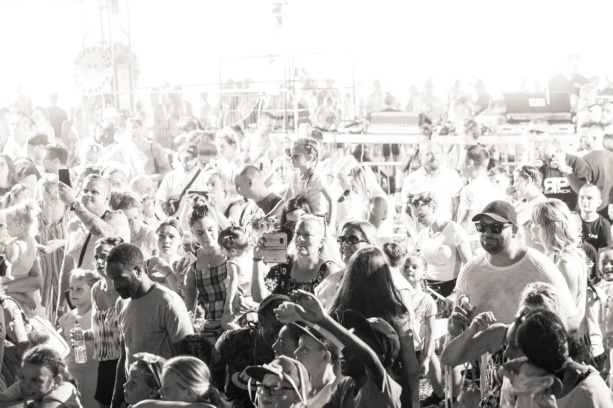 Público heterogéneo reunido num festival de música, celebrando valores de diversidade e empatia