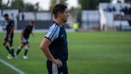 Treinador de futebol orientando a equipa durante um jogo competitivo