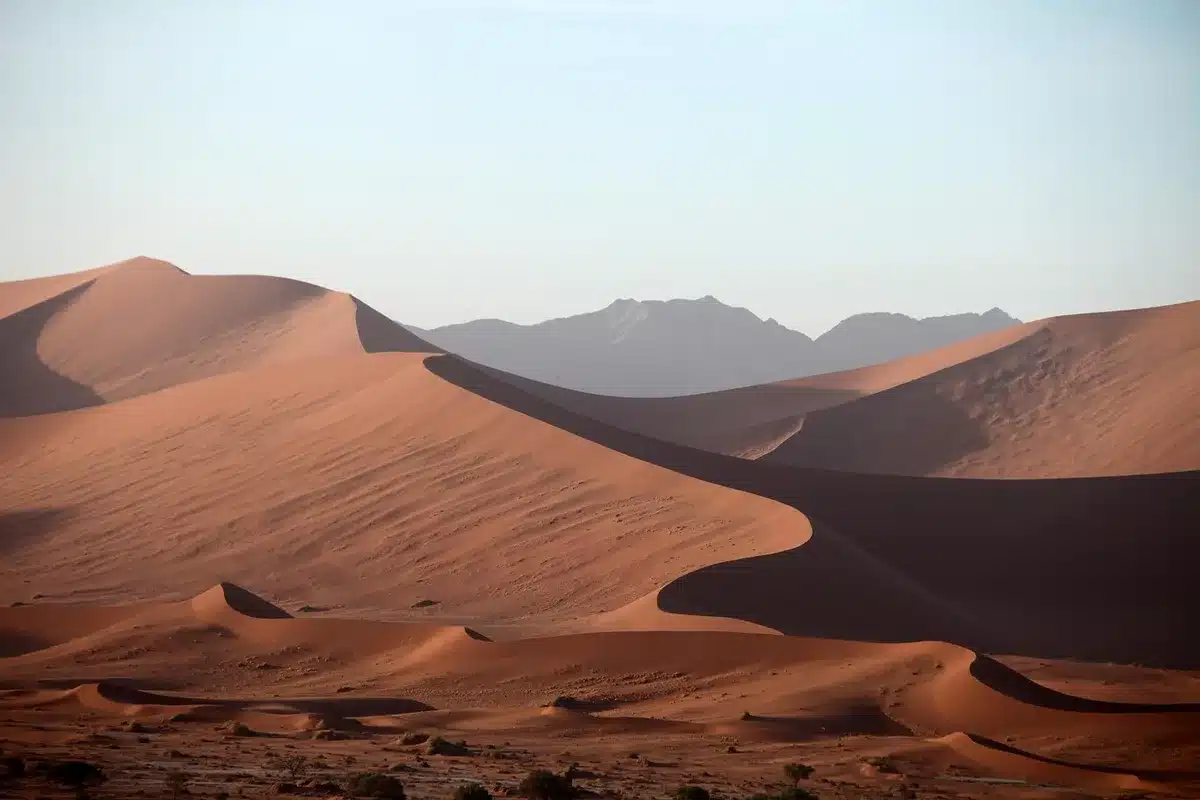 Cidade costeira sob calor extremo e céu seco ilustrando riscos de ondas de calor