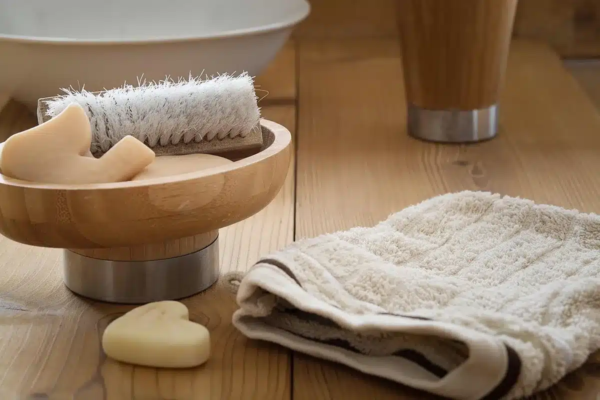 Mãos sobre mesa com produtos de higiene descartados e frascos de suplementos