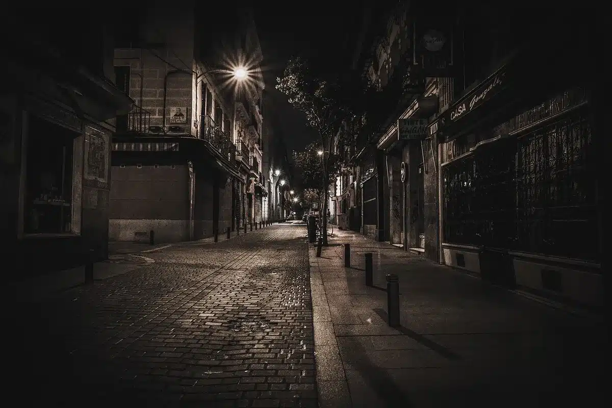Rua histórica com movimentação de entregas e carrinhas de carga