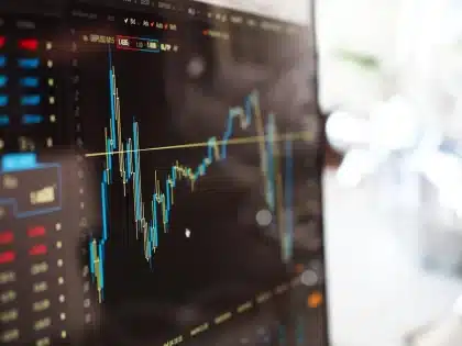 Gráfico de crescimento económico com seta ascendente e bandeira portuguesa em fundo de distrito financeiro