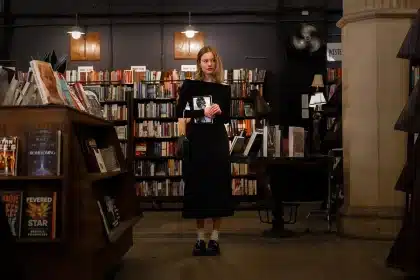 Clientes anónimos a procurar livros e eletrónica numa galeria comercial bem iluminada