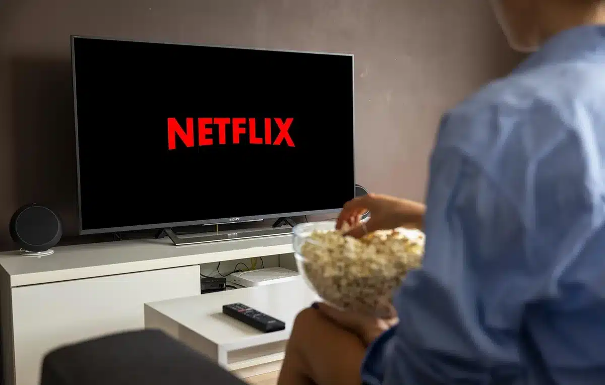 Pessoa a assistir a um filme de suspense em casa à noite