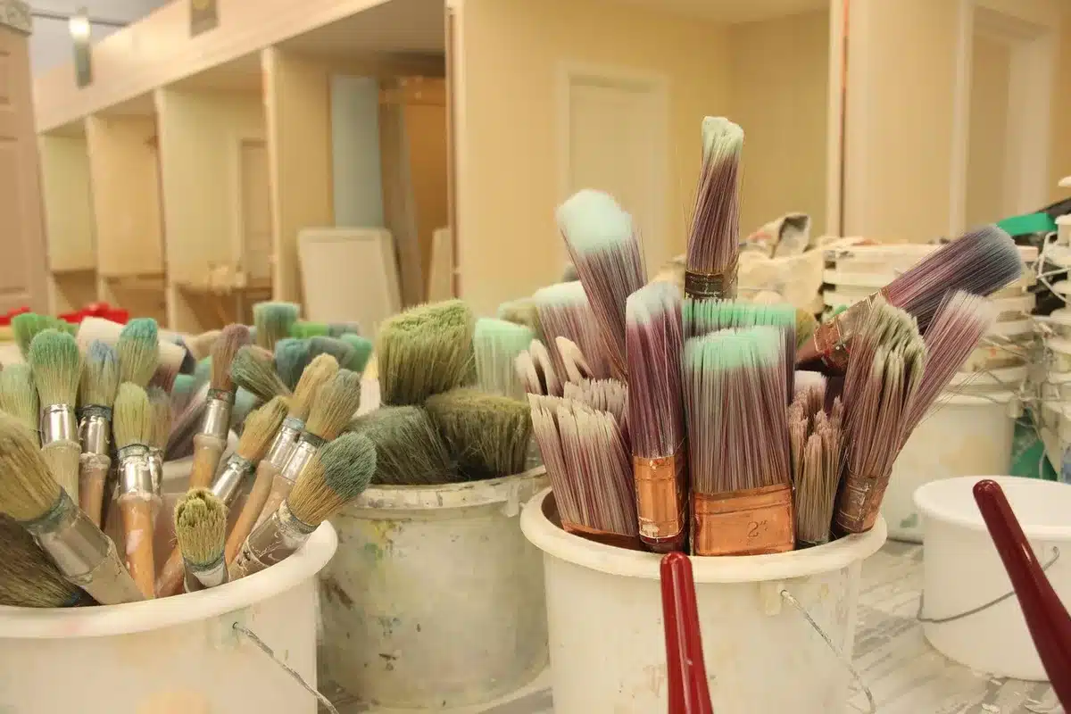 Oficina de pintura com participantes e mesas com materiais