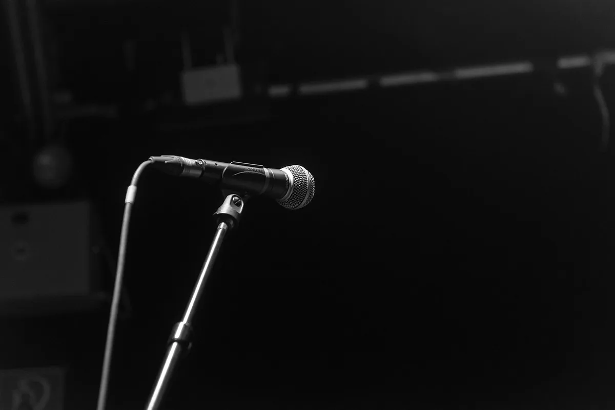 Palco de prémios com microfone e silêncio após um tributo