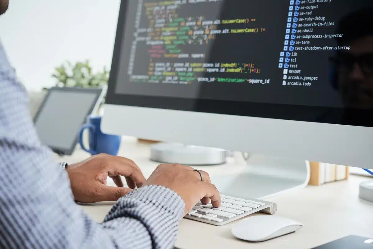 anonymous silhouette at a desk looking at AI model visualizations on a monitor