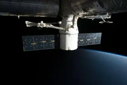 Satélite em órbita no espaço, com a Terra ao fundo e atmosfera visível