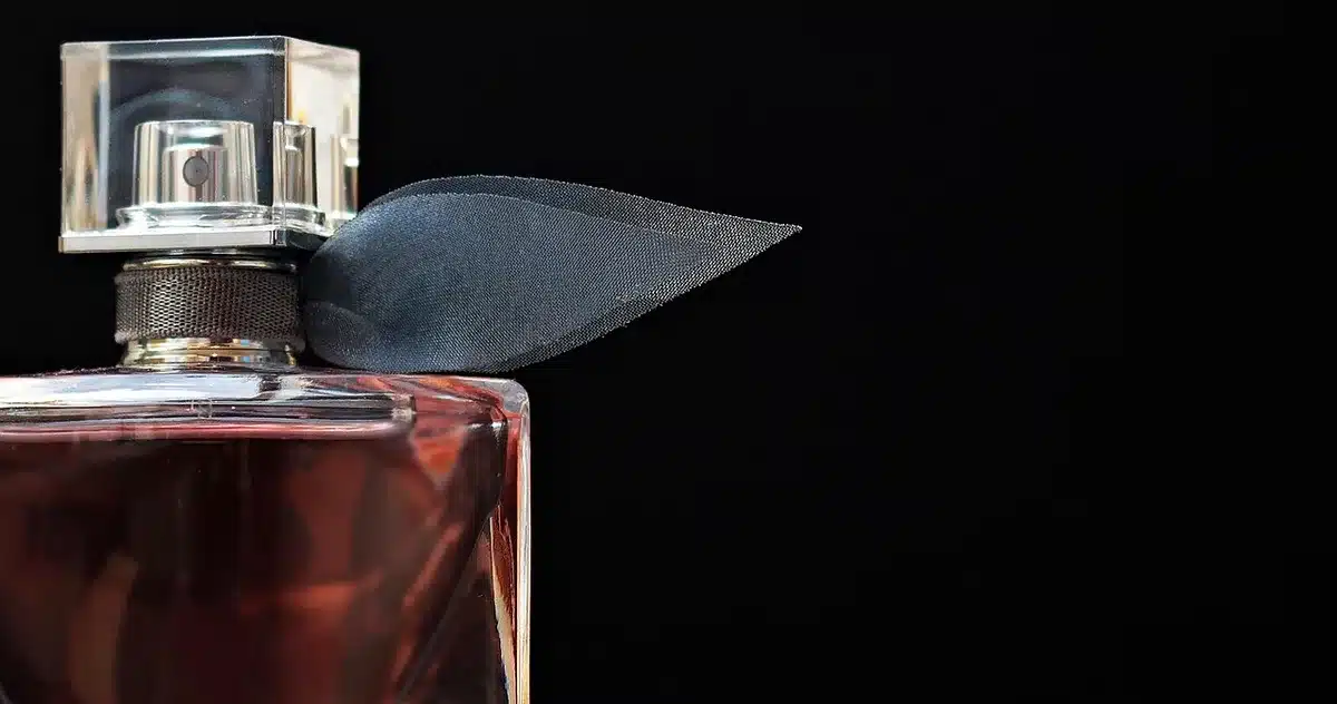 Frasco de perfume e notas como maracujá e baunilha associadas à fragrância