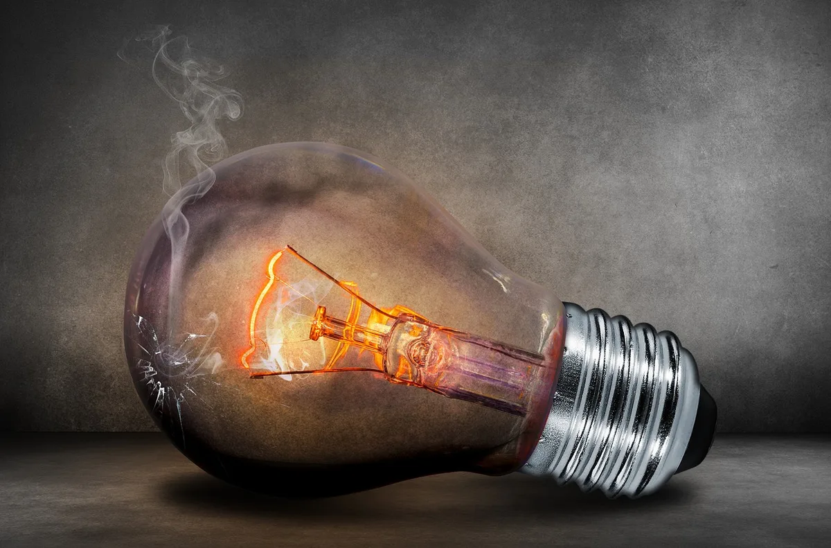 Conta de eletricidade aberta numa mesa com calculadora e caderno de orçamento doméstico