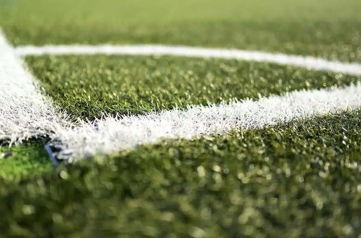 Treinador em comunicação com equipa durante treino no relvado de estádio