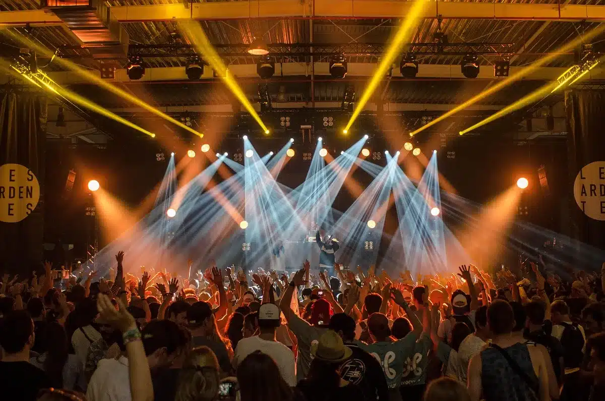 Banda de rock g&oacute;tico em palco durante concerto ao vivo, com guitarras e ilumina&ccedil;&atilde;o dram&aacute;tica
