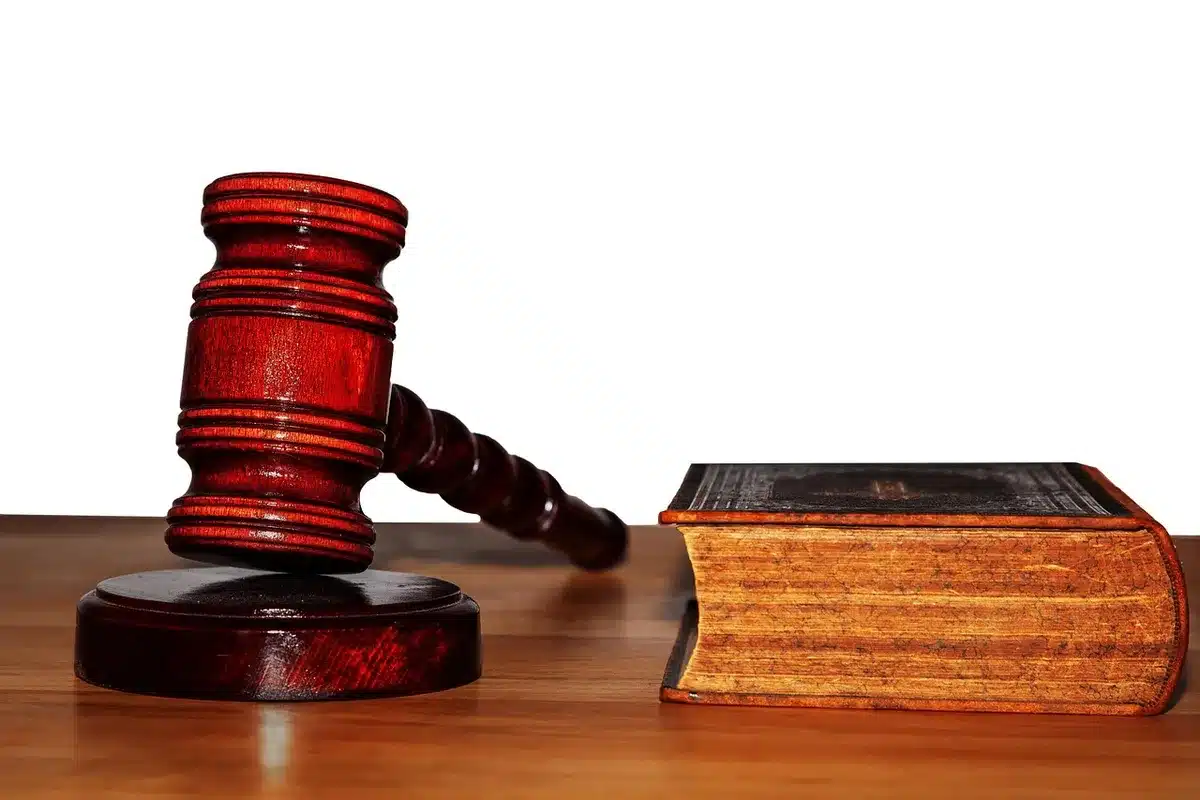 Livros de direito e um martelo judicial sobre uma mesa, simbolizando legislação