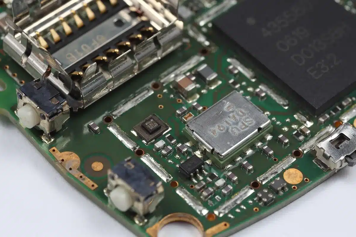 Close-up of a generic circuit board with an anonymous chip and solder points, a small white label with unreadable code blurred out; macro tech lab shot, no brand visible