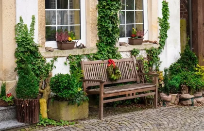 Rua de aldeia com guitarra portuguesa sobre um banco e casas de pedra ao fundo