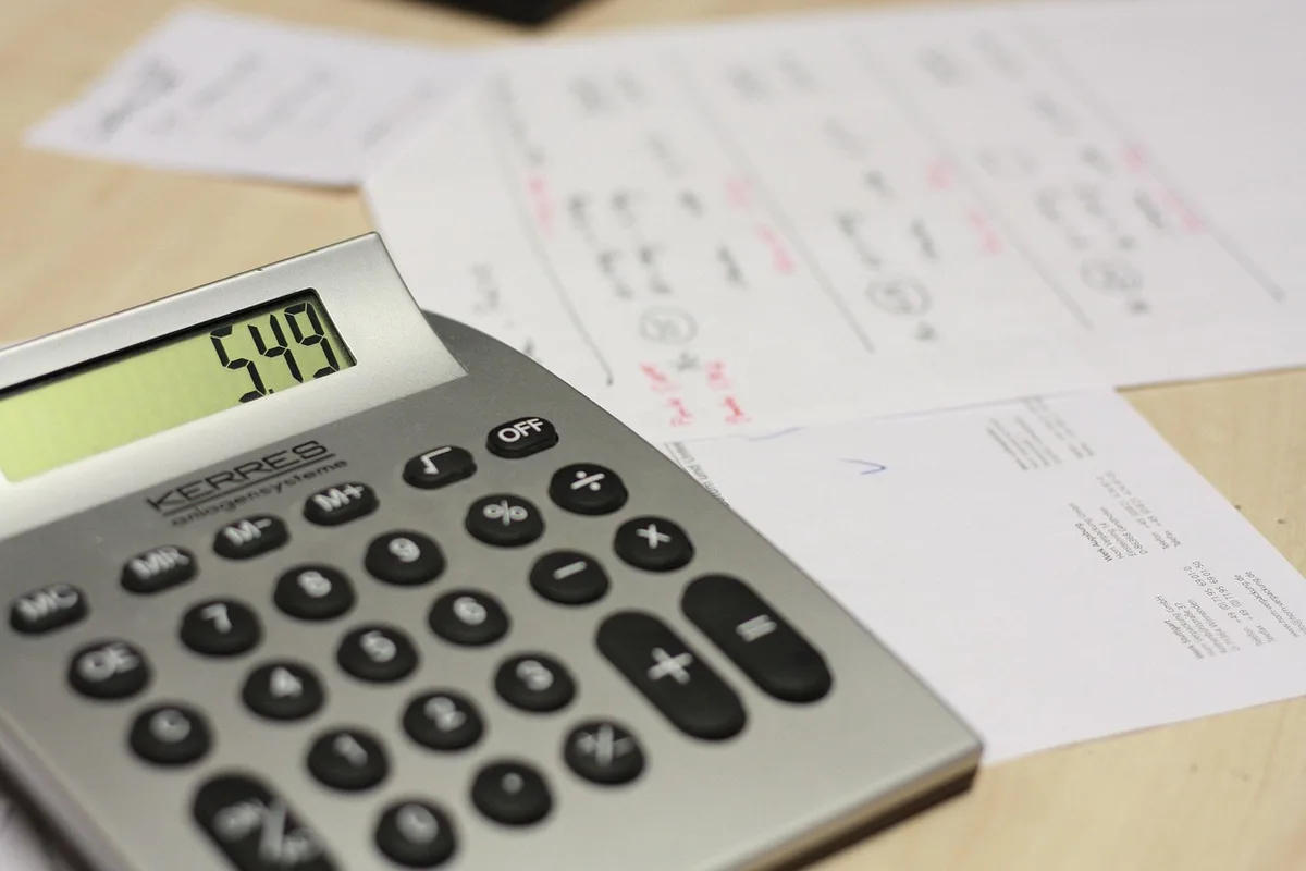 Folha de cálculo com simulações e calculadora mostrando valores de reembolso do IRS