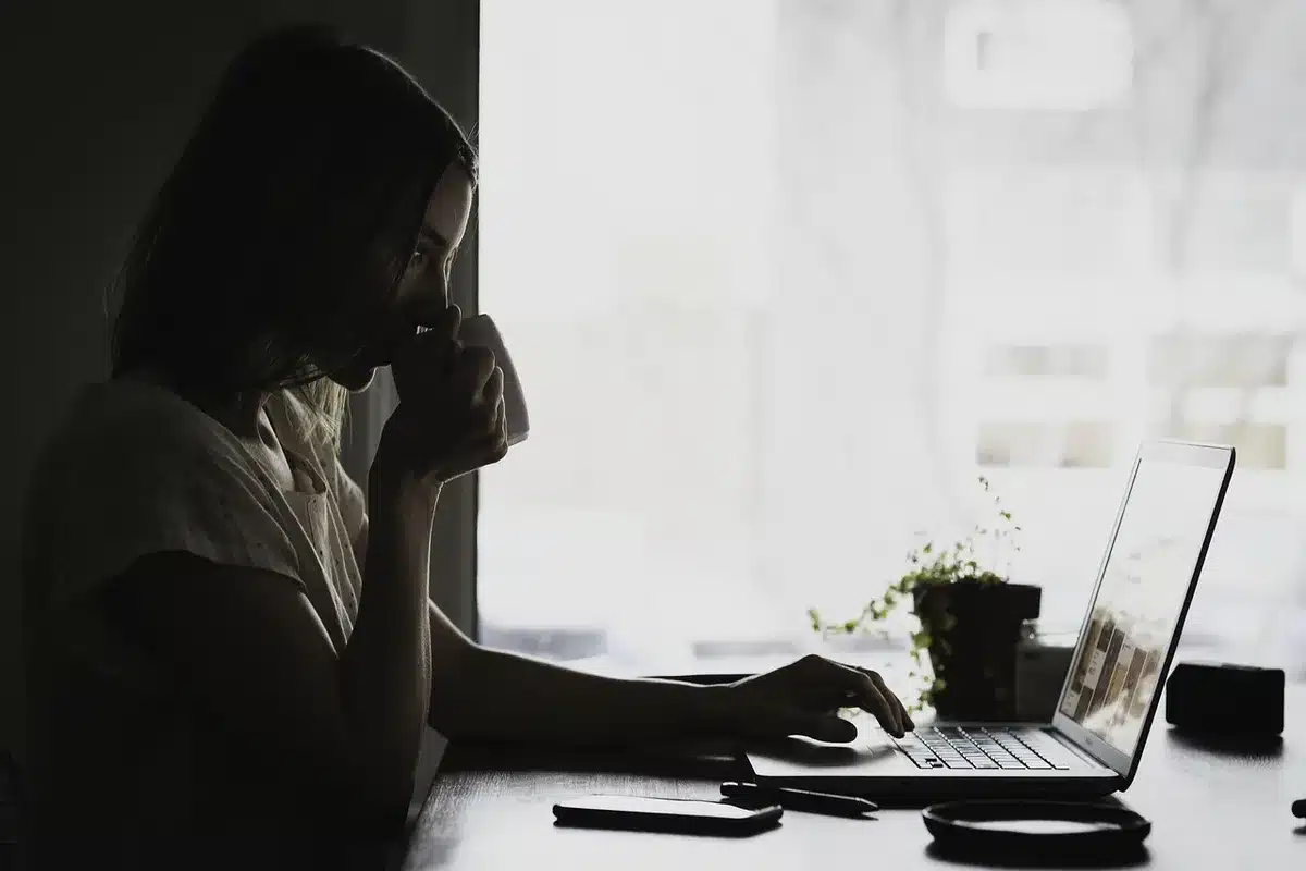 Mesa com gráficos económicos e silhueta de pessoa lendo notas num escritório