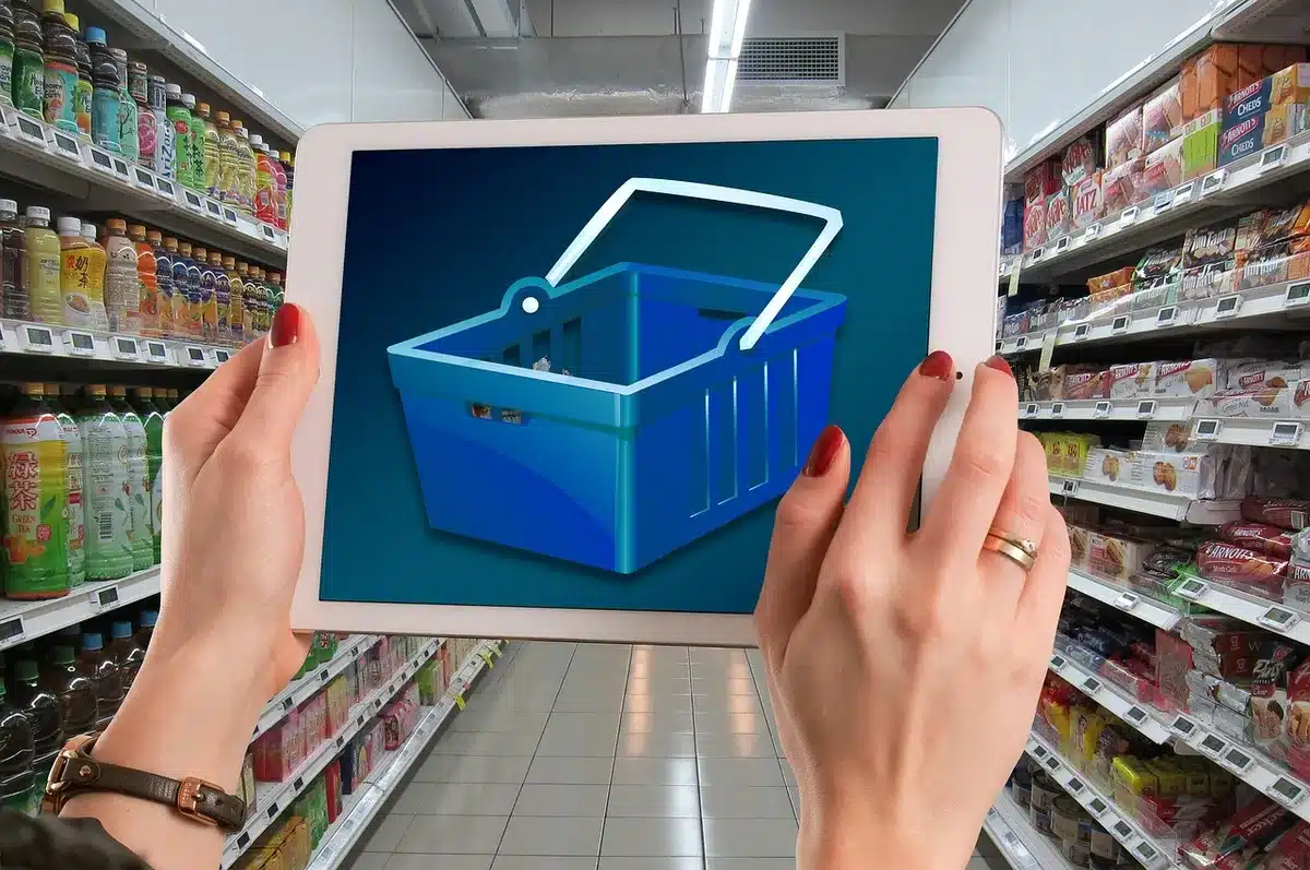 empty supermarket aisle with stacked boxed appliances and anonymous shoppers, seasonal decor visible
