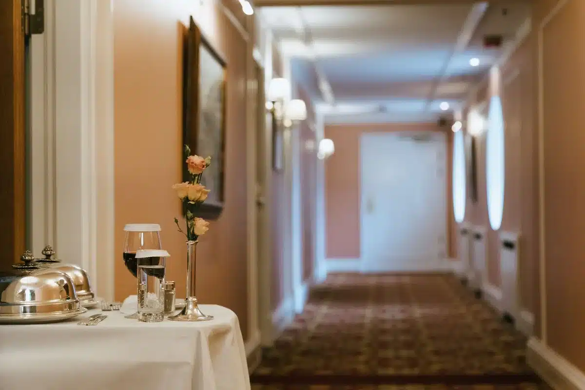 anonymous empty hotel corridor with luggage trolley at far end, soft evening light
