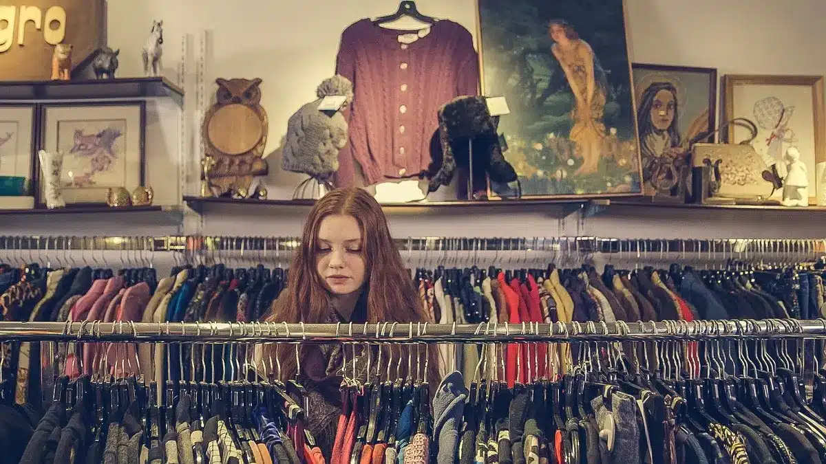 empty shop rail with several anonymous trousers on wooden hangers, neutral lighting, no logos