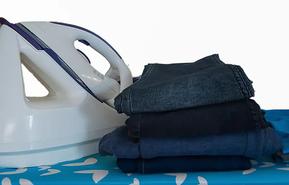 anonymous folded trousers on a wooden table with a paper tag, simple retail setting