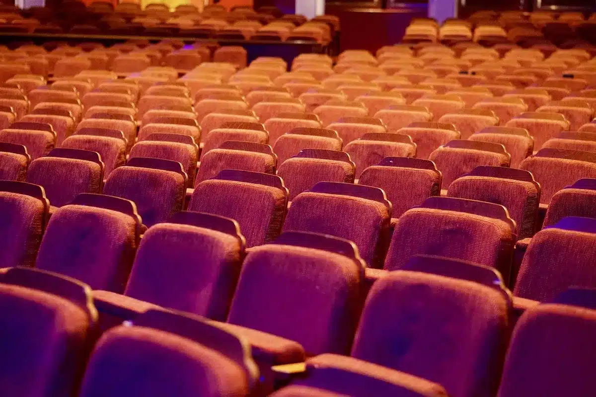 Salas de cinema vazia com tela iluminada e filas de cadeiras
