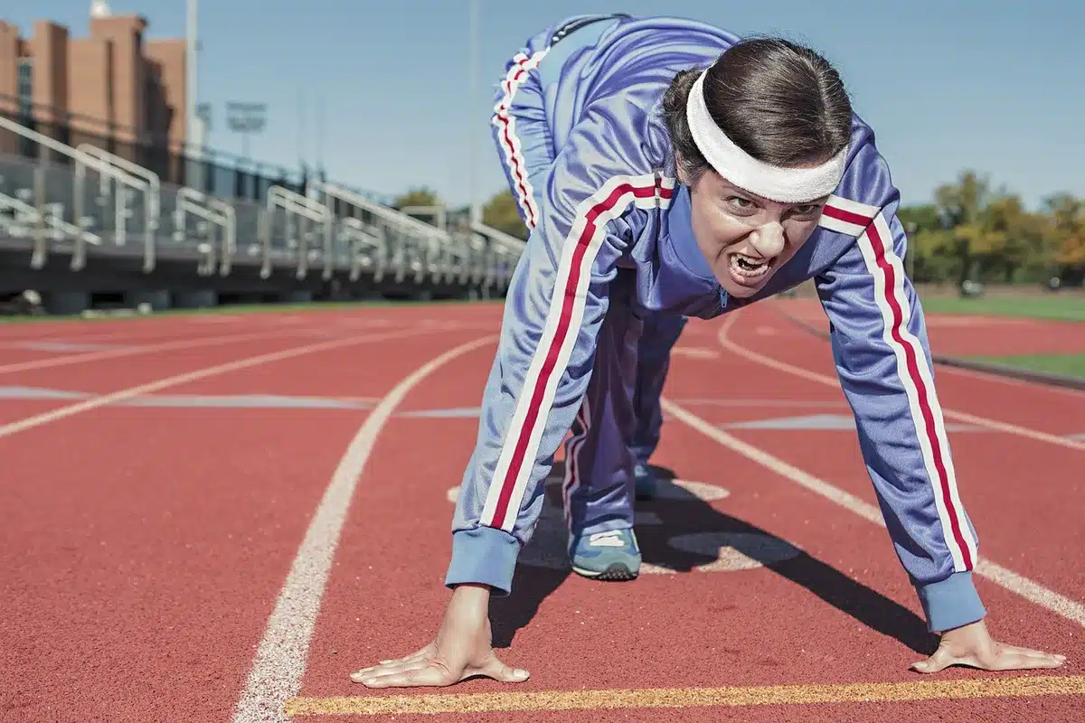 Wide shot of an empty running track at dawn with an unbranded smartwatch and a generic fitness ring placed on the starting line, soft morning light, no people