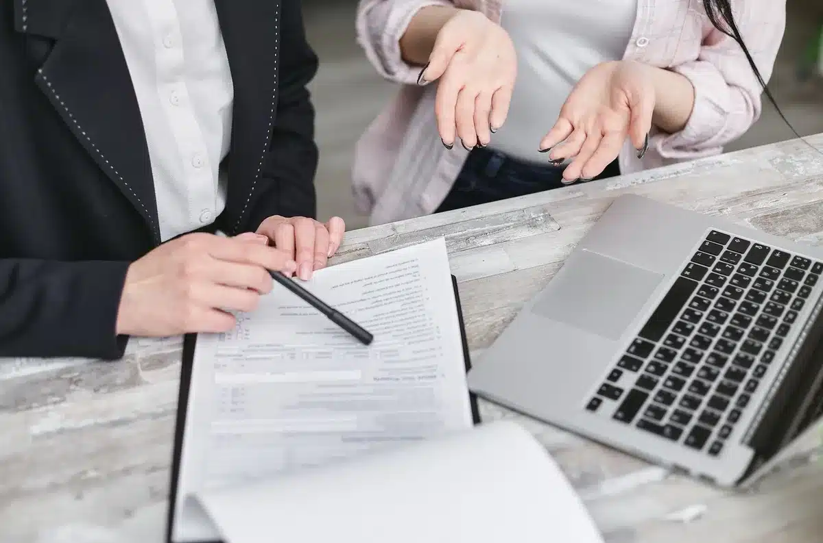 anonymous hands holding tenancy contract pages and calculator on a table