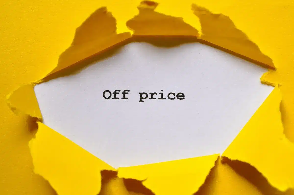 close-up of hands holding a smartphone showing a price comparison page, anonymous hands only
