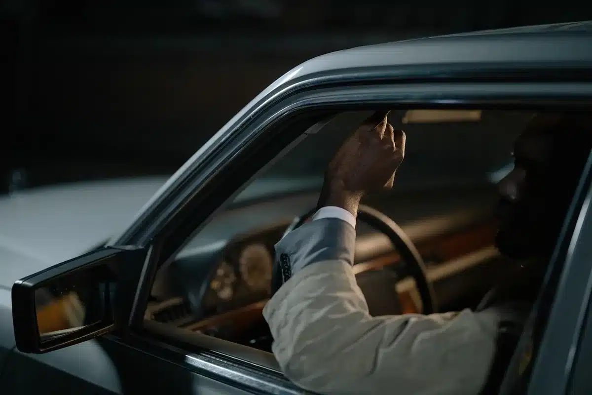 Anonymous driver silhouette looking at a dim dashboard while filling a car at an empty station, no identifiable features