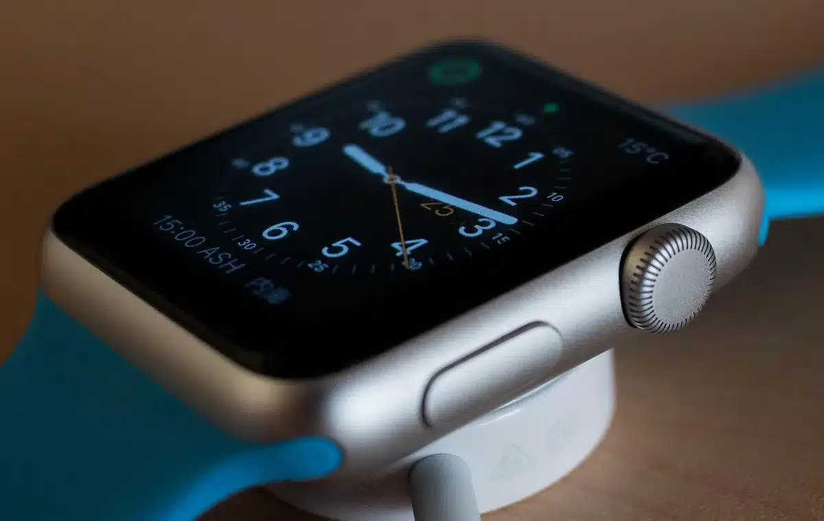 Close-up of an unbranded children's smartwatch on a neutral surface, no logos visible, strap coiled beside it