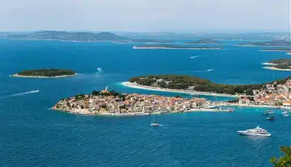 Convés de barco com binóculos e vista para ilhas costeiras, observadores ao fundo