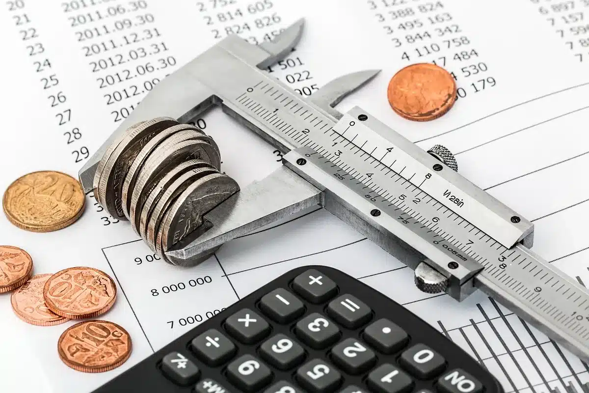Folhas com percentagens e uma calculadora a representar análise da poupança familiar